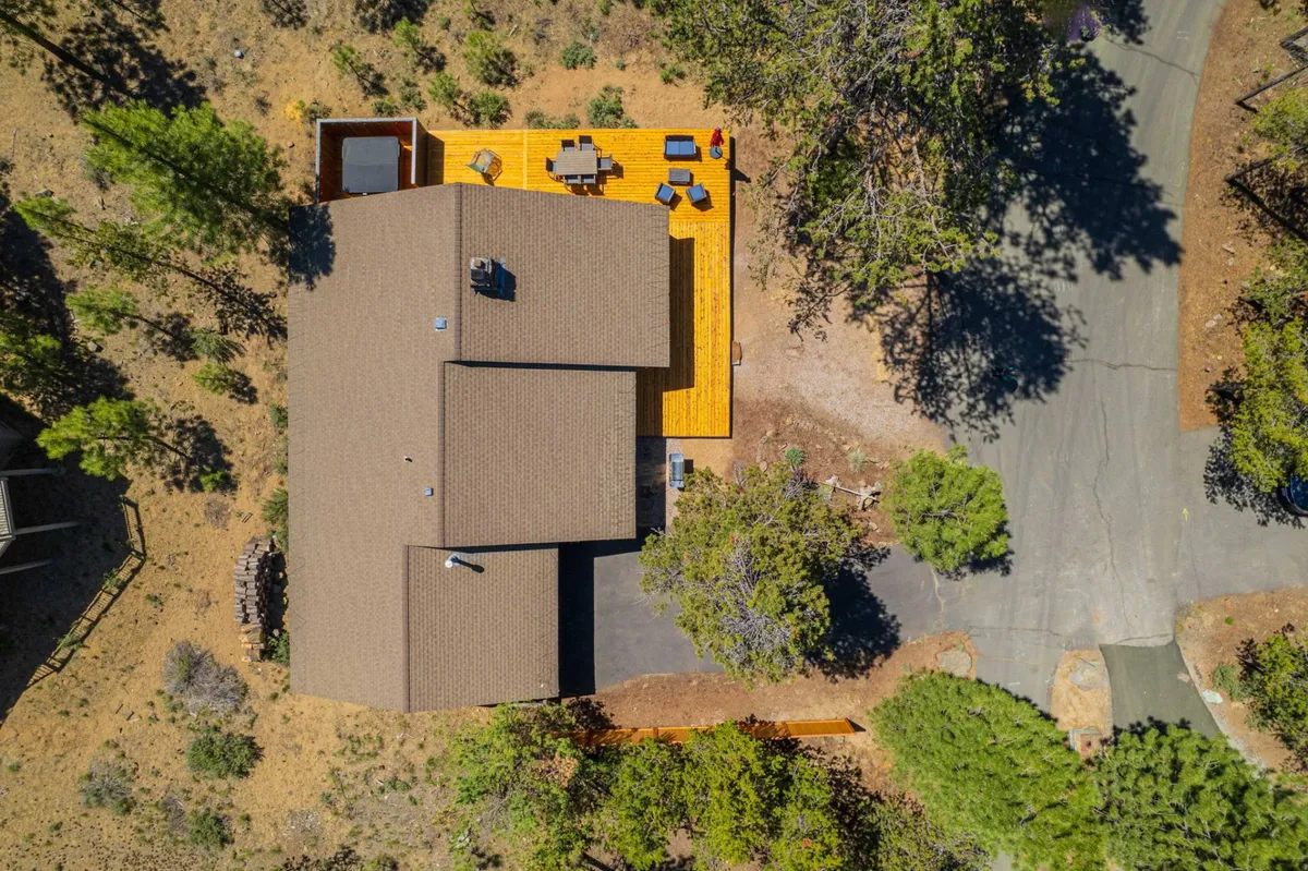Featuring a well-designed deck area with a hot tub and comfortable outdoor seating, this image presents landscaped surroundings that emphasize privacy and tranquility. The mix of hardscaped and natural elements complements the narrative of modern amenities blending with nature.